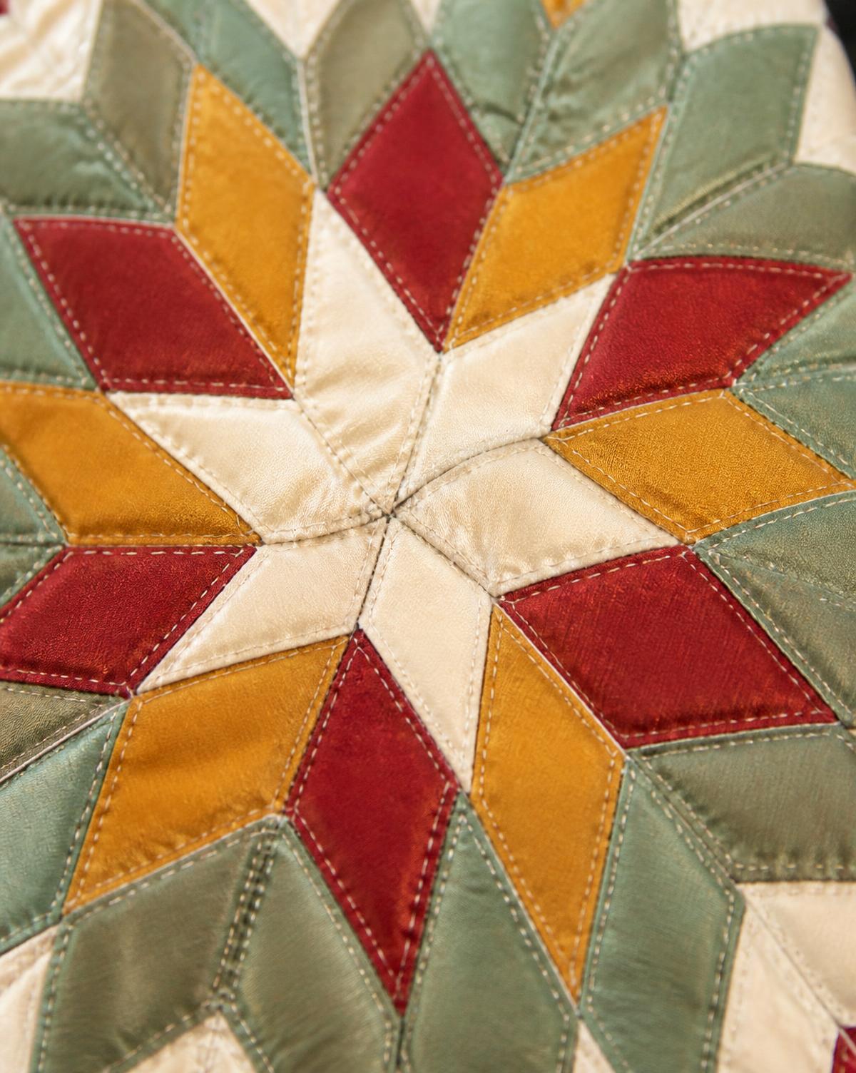 Macro detail of hand-stitched star quilt diamond points
